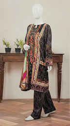 Mannequin wearing a patterned outfit with a wooden table and plants in the background